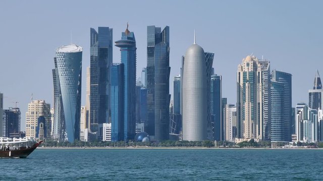 Traditional Dhow, Arab vessels, sailing with Qatar flag in front of the Doha skyline