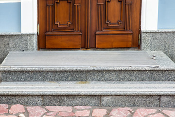 gray granite threshold with steps covered with non-slip rubber strips at the entrance wooden door...