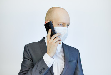 image of business man wearing anti bacterial mask against virus and pollution with smartphone in hand