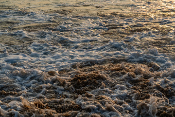 golden colors of the sunset, reflected on the sea water surface