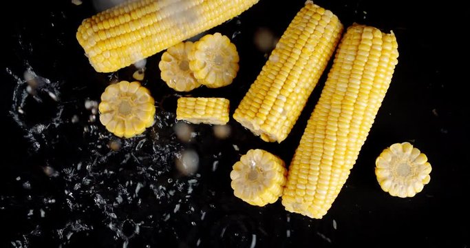 Water drops fall on the pieces of corn.