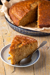 Top view of serving on plate and spoon, with sponge cake in the background and selective focus, on rustic wooden board, vertical