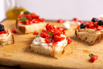 Mix of bruschette with cherry tomatoes and cream cheese, hummus and black olives. Italian food, healthy appetizer
