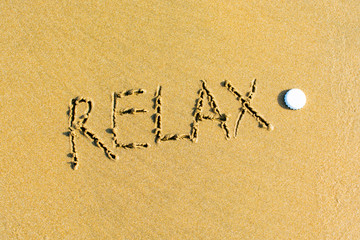 Relax written on a sandy beach.