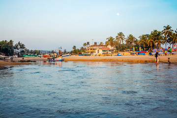 Goa, India - 15 January 2020: View of a small Indian river with wooden fishing boats on Baga Beach, Goa, India