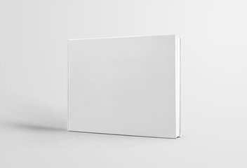 Closed white book template with realistic shadows, standing for presentation of design and...