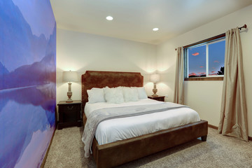 Bedroom interior with purple mountains on the walls and brown sude bed