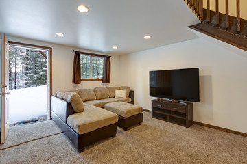 Living room interior with beige sofa, natural touches, custom build wooden bunk bed, tall ceiling with loft.