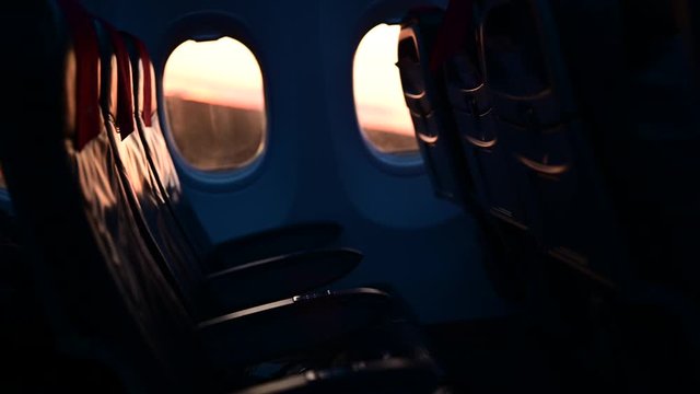 Inside interior of an empty airplane. Plane taking off with no people or passengers on the empty seats. Nobody flying on the airplane. Groud moving seen through the window