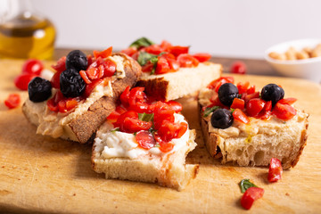 Mix of bruschette with cherry tomatoes and cream cheese, hummus and black olives. Italian food, healthy appetizer