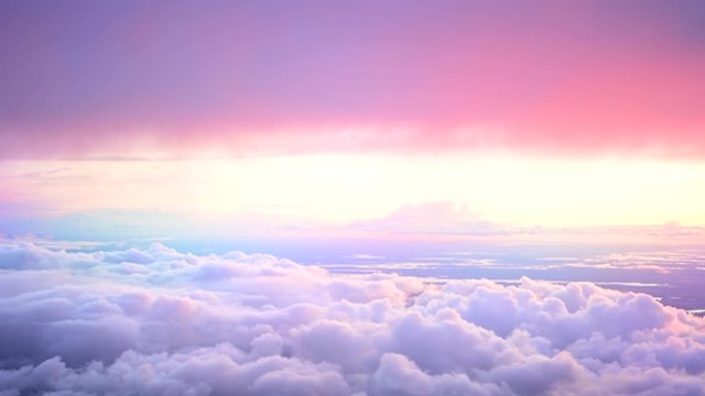 Beautiful colourful cloudscape. View over or above amazing heaven like clouds. Fluffy soft pink and purple fairy tale sunrise or sunset sky moving. Like paradise