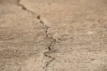 A cracks on the concrete floor. Surface of concrete covered with cracks,close up of crack cement road,concrete texture closeup background.