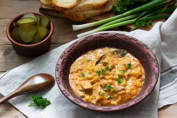 Bean and meat stew, served with pickles, bread and garlic. Rustic style.