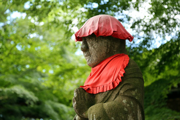 Stone statues of monks filled with traces of years, standing in the forest and wishing travelers a...