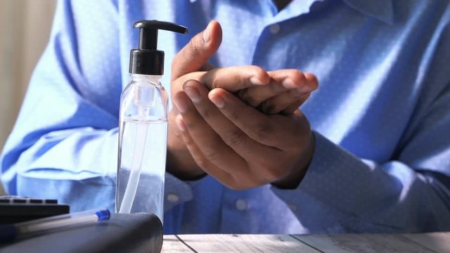 Businessman hands using wash hand sanitizer gel dispenser