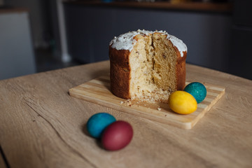 Easter cake with colored easter eggs on a wooden board on a table. Easter concept.