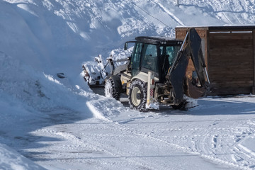 Tractor removing snow after snowfall. Winter season. Snow clearing. Tractor clears the way after heavy snowfall.
