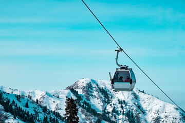 Cable car way on snowy mountains background. Gondola lift in winter mountains.