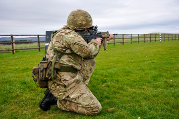 A soldier trains on a military firing range with an assault rifle.