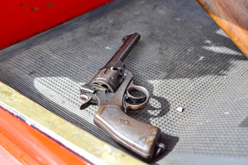 A WW1 era revolver lying on the footwell of an old car