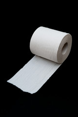 Single roll of unrolled white toilet paper. Isolated on black background. Close-up. Copy space. Vertical shot.