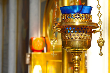 Church lamp in front of the icon. A burning lamp, a candle in a blue flask sways in front of the...