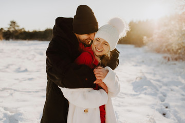 couple in love, husband and wife for a walk in the winter forest, snowing snow, happiness joy, emotional walk at sunset, winter