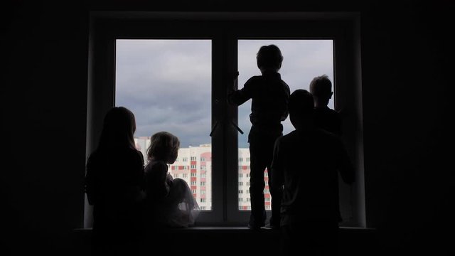 Silhouette of a large family on the background of a window in a new apartment. Quarantine concept.