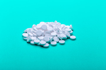 A pile of pills on a green background.