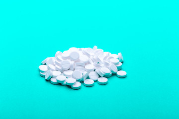 A pile of pills on a green background.
