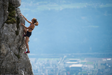 Obraz premium Girl climbing on the rock