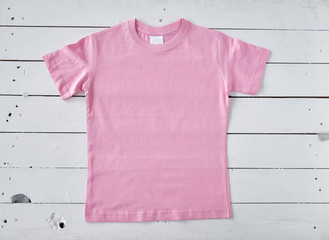 Pink t-shirt on white wooden background