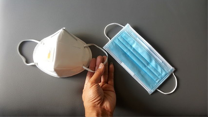 
Holding surgical mask (medical face mask) or PM 2.5 , 2019-nCoV, Anti Coronavirus protection, Surgical mask protective on grey background. covid-19 virus outbreak.