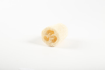 Obraz na płótnie Canvas Natural environmental loofah designed for the body, lies on a white background.