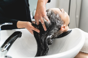 Focused photo on female hands that washing hair