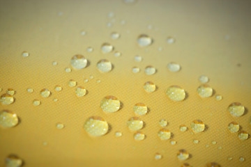 Fototapeta na wymiar fresh water drop on yellow background