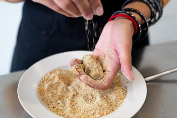 Close up of woman hands cooking homemade croquettes at home