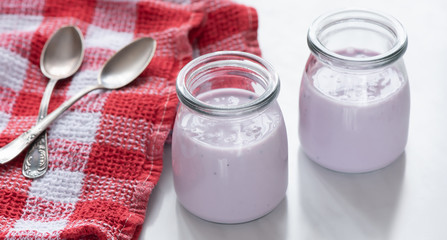 two glasses of healthy blueberry yogurt on white table. healthy breakfast