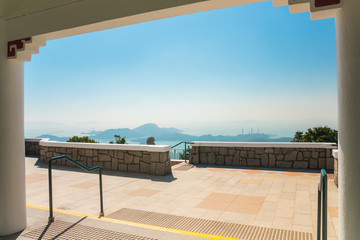 Fototapeta na wymiar Hong Kong horizon. Views from a pavilion built on the site of the former Mountain Lodge (an alternate residence for the Governor of Hong Kong). Beautiful sunny day with a blue sky.