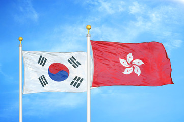 South Korea and Hong Kong two flags on flagpoles and blue cloudy sky