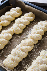 Preparation process - raw unbaked buns. Yeast dough buns on baking paper, close-up.