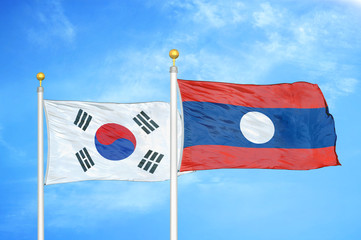 South Korea and Laos two flags on flagpoles and blue cloudy sky