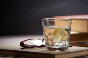 still of lemon water with book and glasses