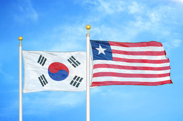 South Korea and Liberia two flags on flagpoles and blue cloudy sky