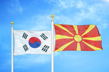 South Korea and North Macedonia two flags on flagpoles and blue cloudy sky