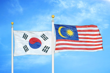 South Korea and Malaysia two flags on flagpoles and blue cloudy sky