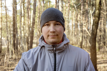 Street portrait of a smiling man of 30-35 years of Eastern appearance in the forest, close-up....