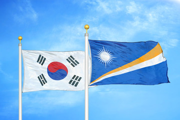 South Korea and Marshall Islands two flags on flagpoles and blue cloudy sky