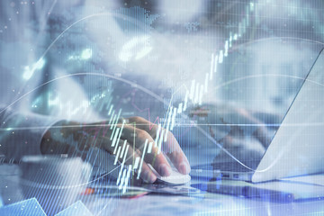 Double exposure of forex graph with man working on computer on background. Concept of market analysis.