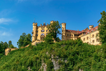 Fototapeta na wymiar Panoramic view of the main facade of Hohenschwangau Castle in yellow. Photograph taken in Schwangau, Bavaria, Germany.